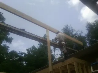 Carpenter setting a ridge beam over a new addition frame — Ice Dam Removal by Roofing Brothers in Hartville