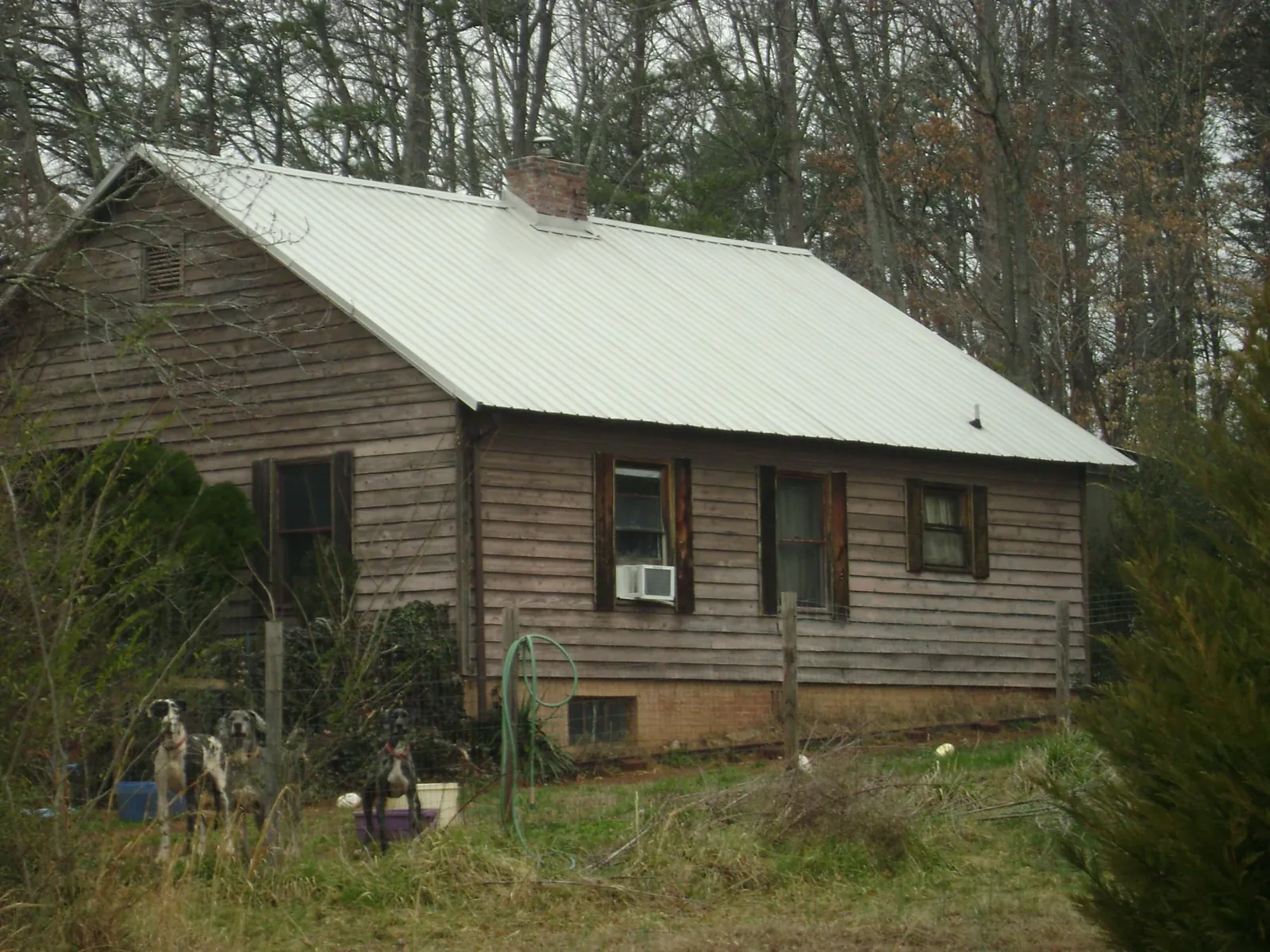 White metal roof on an old wood sided farmhouse, from a Metal Roof Installation job in Hartville
